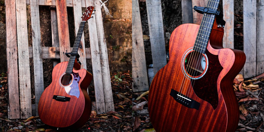 Violão Elétrico Seizi Originals Kaizen Neo Shogun em pé em um suporte de chão em um cenário com folhas ao fundo